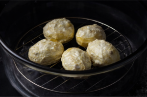 Potatoes arranged on the rack in an air fryer